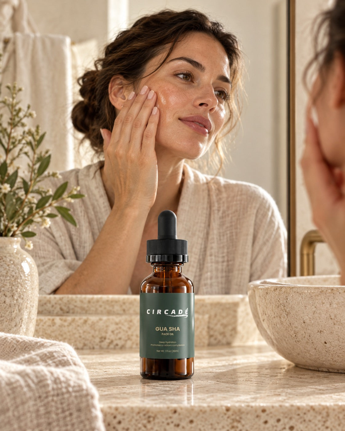 Circade Gua Sha Face Oil on a vanity as a woman massages her face